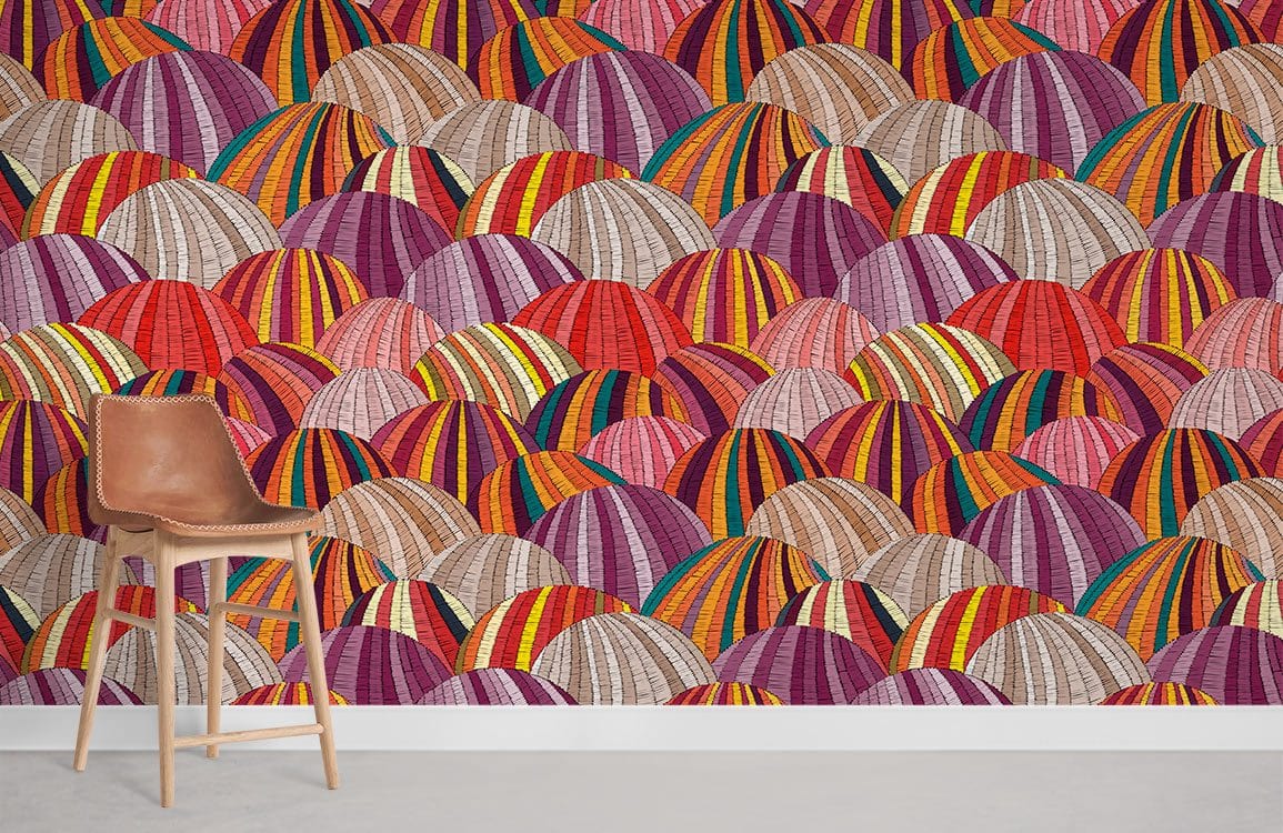 Vibrant geometric mural wallpaper with multi-coloured domes, modern wall design featuring brown leather chair.