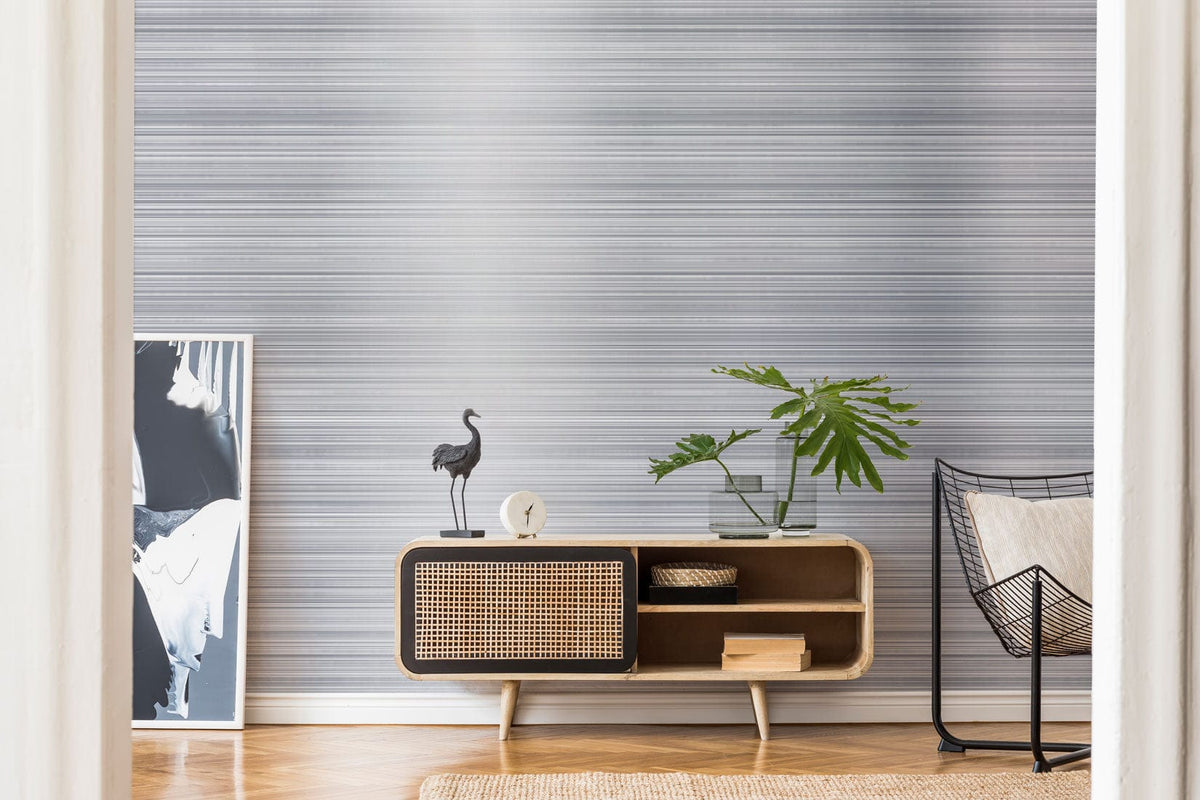 Elegant grey striped wallpaper, modern minimalist style, mid-century console, armchair, and wood flooring.