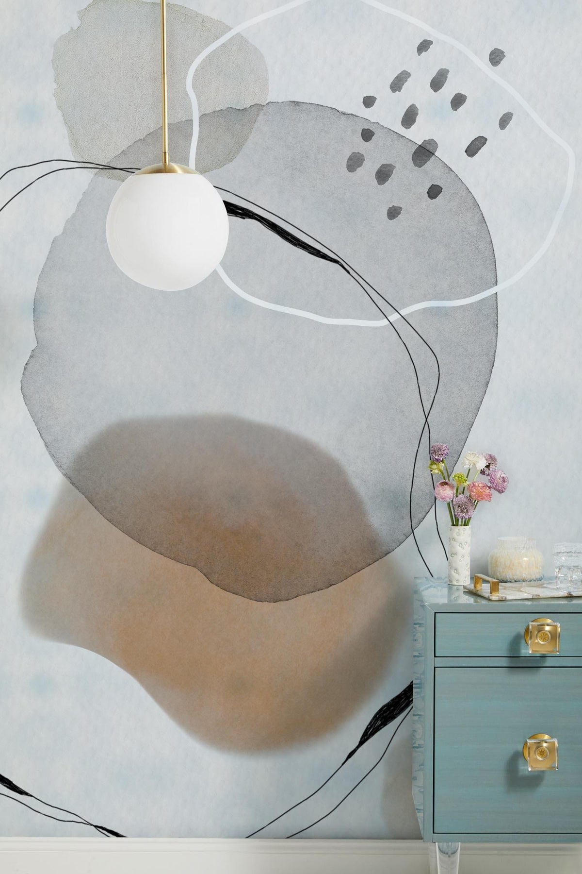 Abstract watercolour mural wallpaper with a pendant light, blue drawer unit, and modern interior decor.