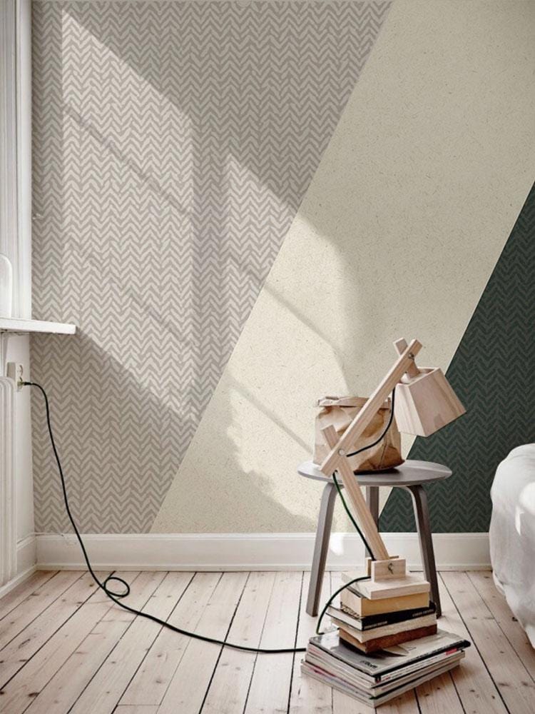 Modern geometric wallpaper with green and grey triangles in a bedroom with wooden flooring.