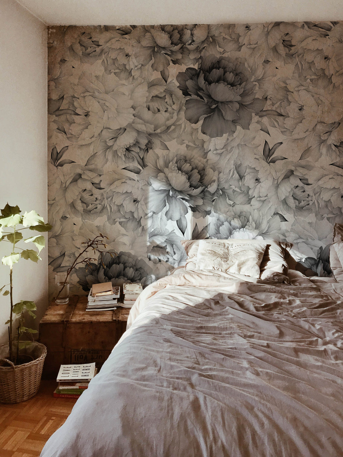 Elegant monochrome floral wallpaper in bedroom, featuring bed, wooden flooring, and complementary decor items.