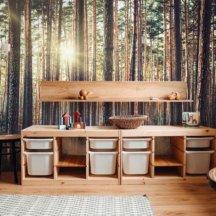 Sunlit Forest Mist mural wallpaper decor in children's room with wooden storage units and sunlight effect.