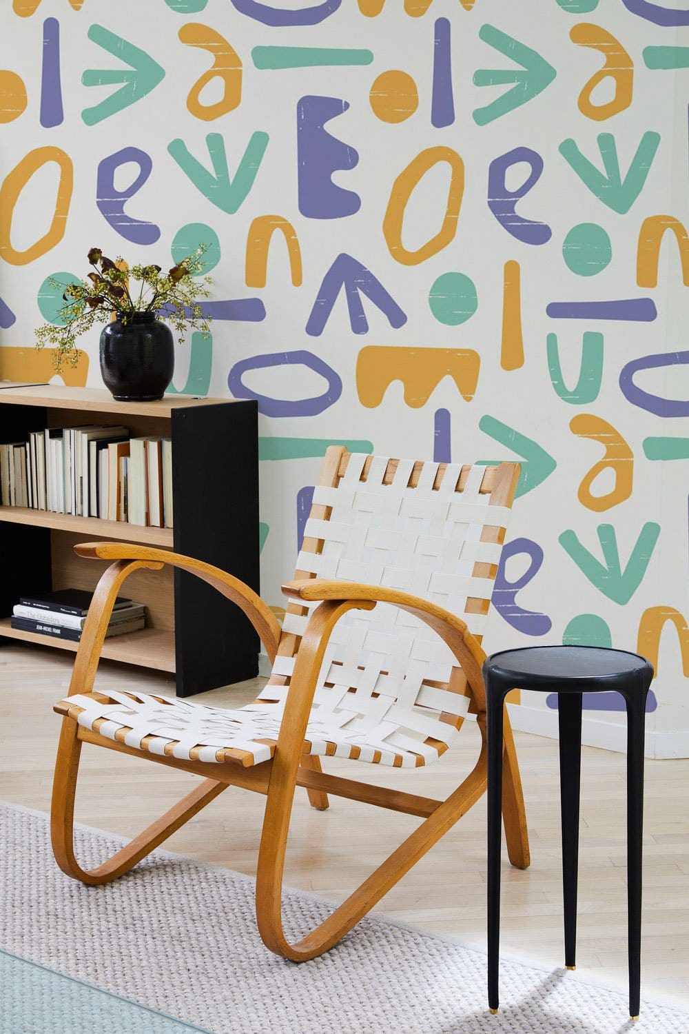 Playful Pastel Geometric Wall Mural in modern room with wooden chair, side table, light flooring.
