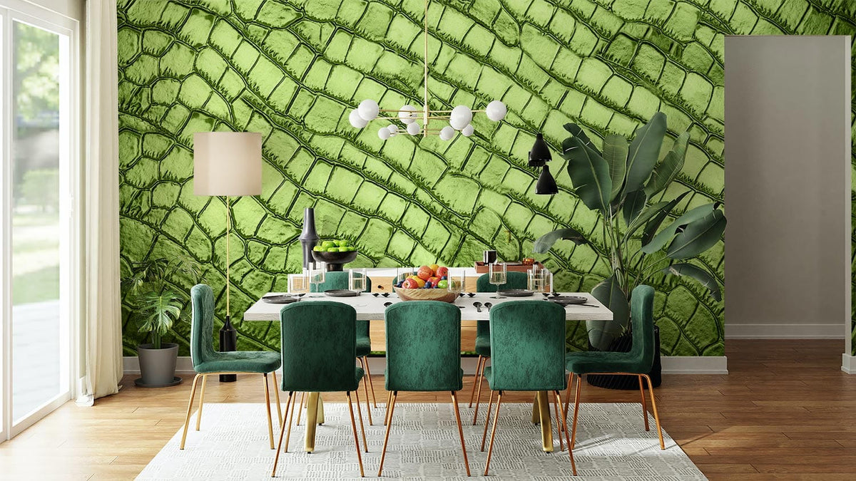 Green reptile skin effect wall mural in dining room with green velvet chairs and wooden flooring.