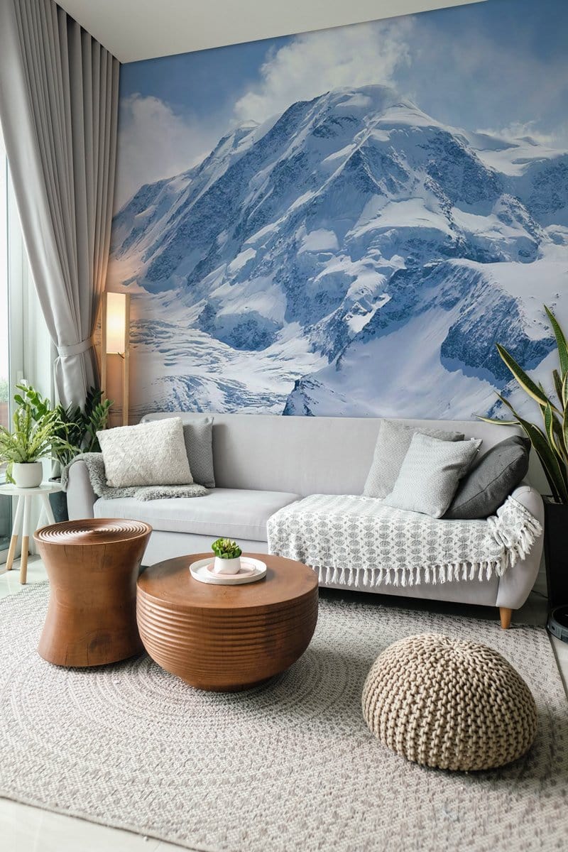 Majestic Snowy Mountain mural wallpaper in living room with grey sofa, wooden coffee table, and rug.