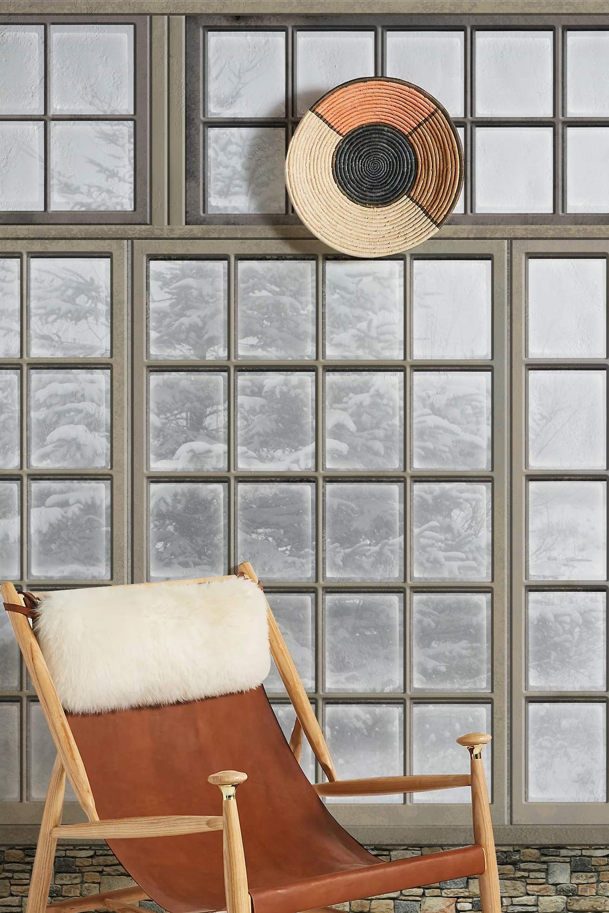 Rustic window mural with snowy scene, leather chair, fur accent, and woven wall decor.