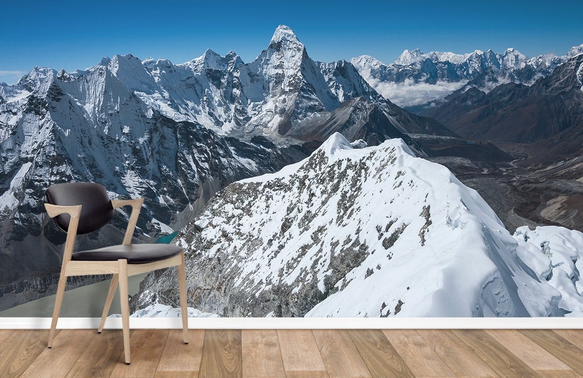 Majestic snow-capped mountain mural, serene blue tones, wooden flooring, modern chair, relaxing interior setting.