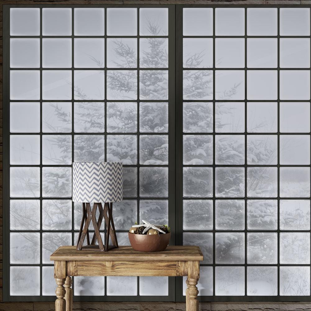 Frosted Winter Window Mural Wallpaper, rustic wood table, patterned lamp, serene snowy landscape.