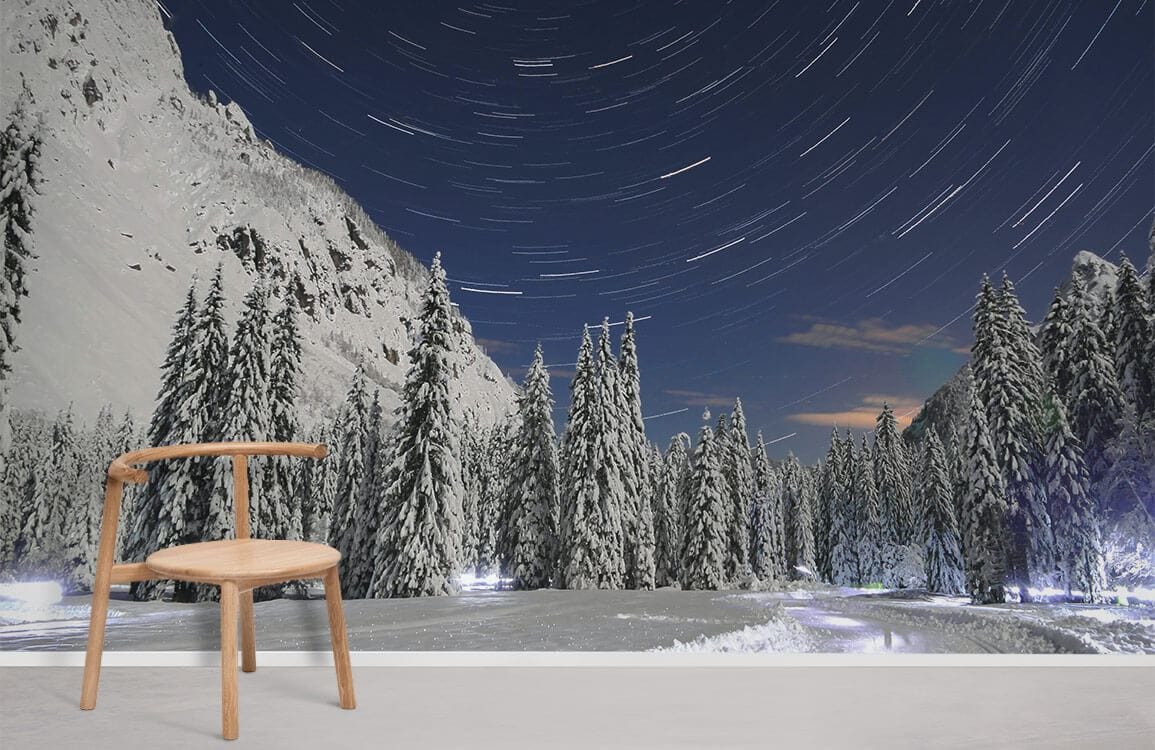 Snowy forest mural wallpaper in minimalist room with wooden chair and light flooring, night sky design.