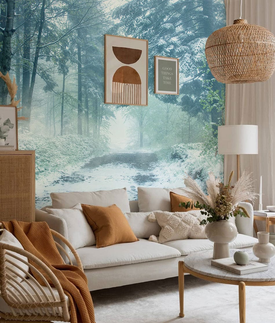 Serene winter woodland mural in living room with cosy sofa, wooden decor, and textured neutral furnishings.