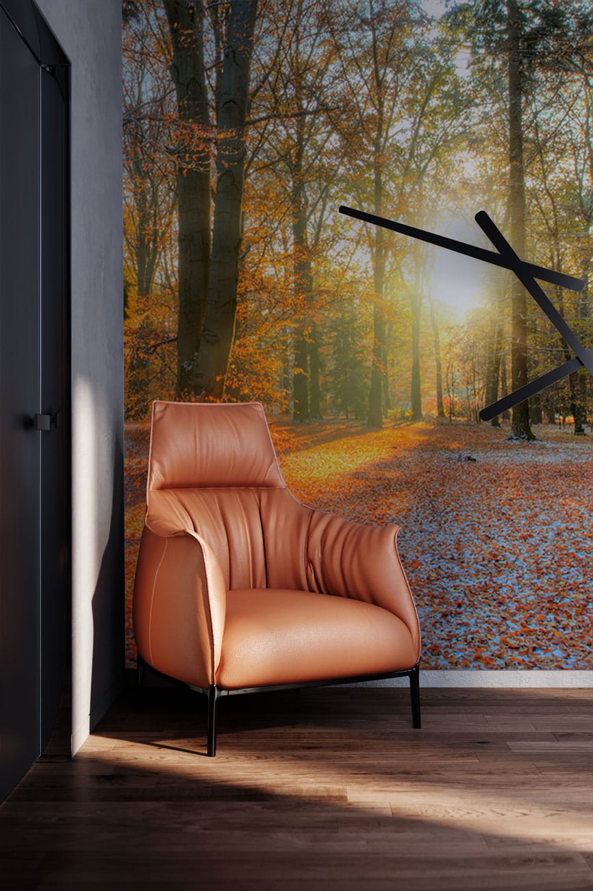 Enchanting autumn forest mural wallpaper, brown leather chair, wooden flooring, modern wall clock, cosy living room.
