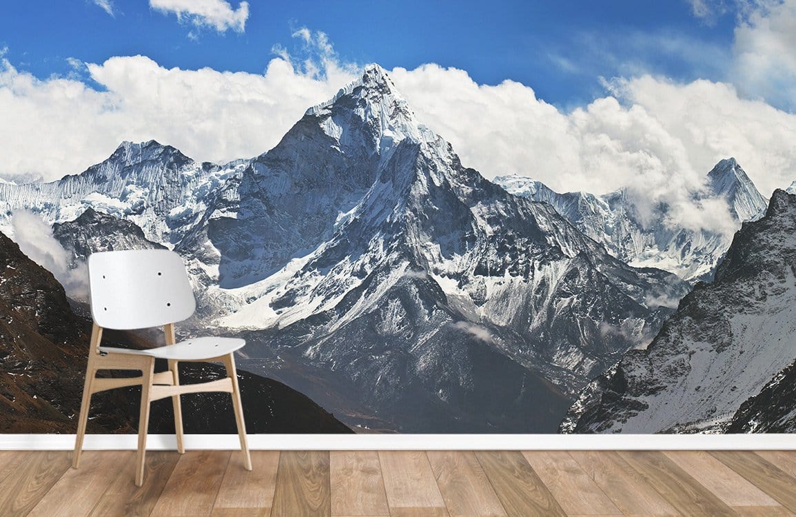 Majestic snow-capped mountain mural wallpaper with white chair, wooden flooring, in modern room setting.