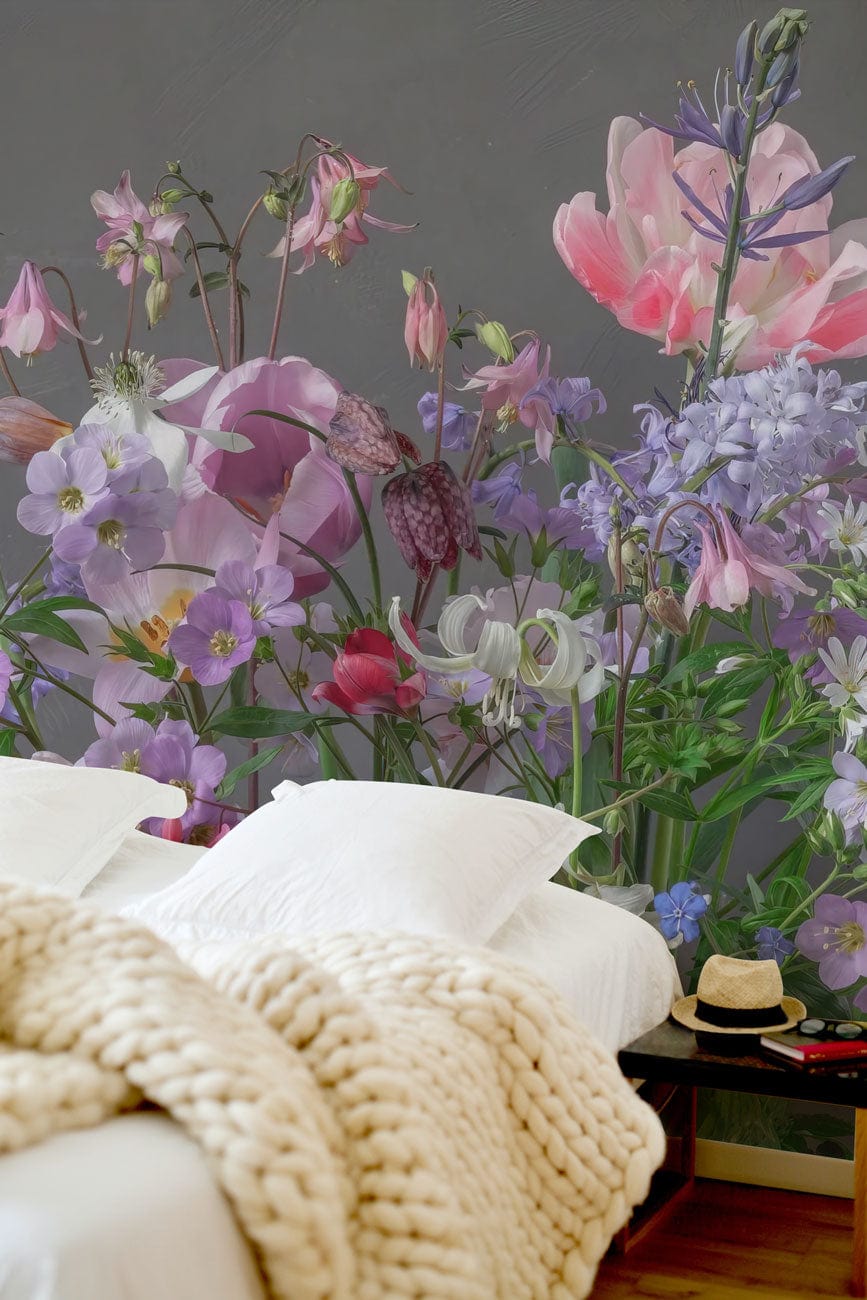 Vintage Pastel Floral Wallpaper Mural with pink-purple blooms, cosy knitted blanket, wooden floor in bedroom.