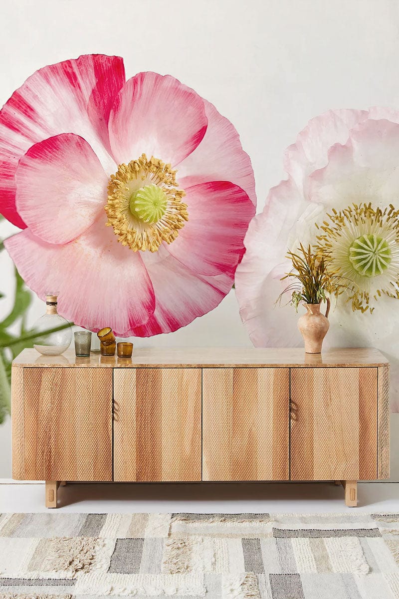 Romantic pink floral wallpaper, light wood cabinet, woven rug, nature-inspired mural design, contemporary decor.