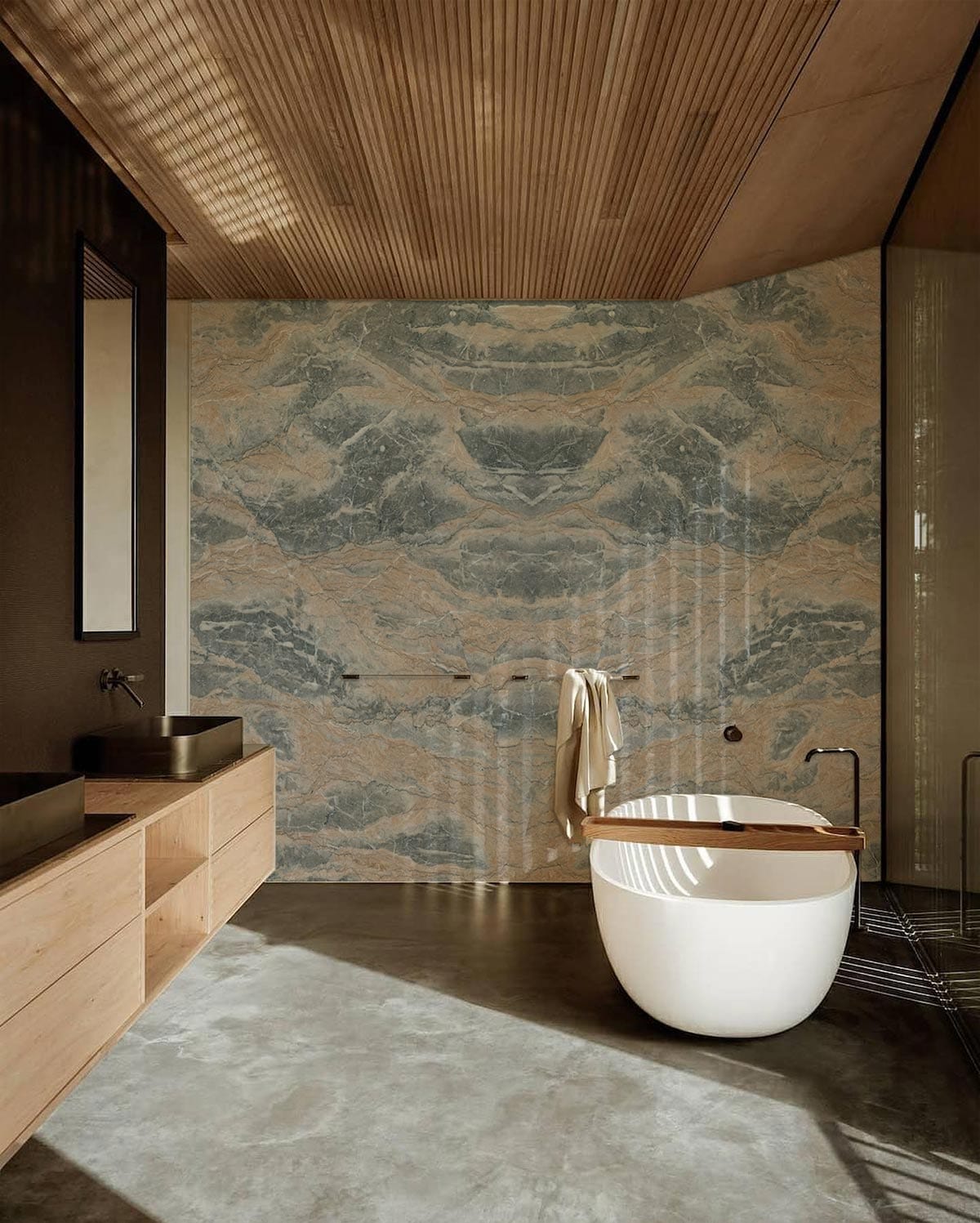 Earthy marble wallpaper in modern bathroom with wooden ceiling, concrete floor, and freestanding white bathtub.
