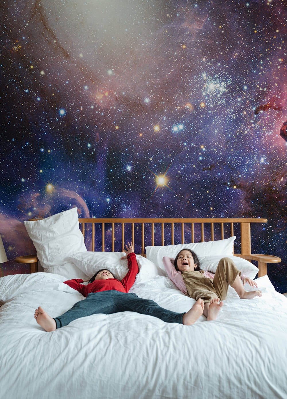 Celestial Galaxy Nebula mural with stars in bedroom, wooden bed, white bedding, cosmic night design.