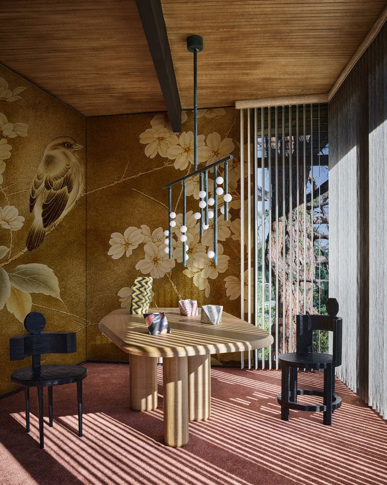 Vintage Floral Bird Mural Wallpaper in golden tones, modern dining table, black chairs, wooden ceiling.