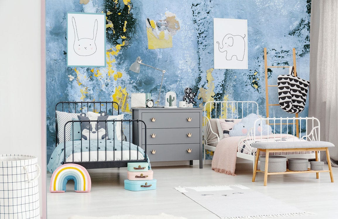 Children's room with abstract blue and gold mural wallpaper, grey dresser, colourful decor, modern beds.