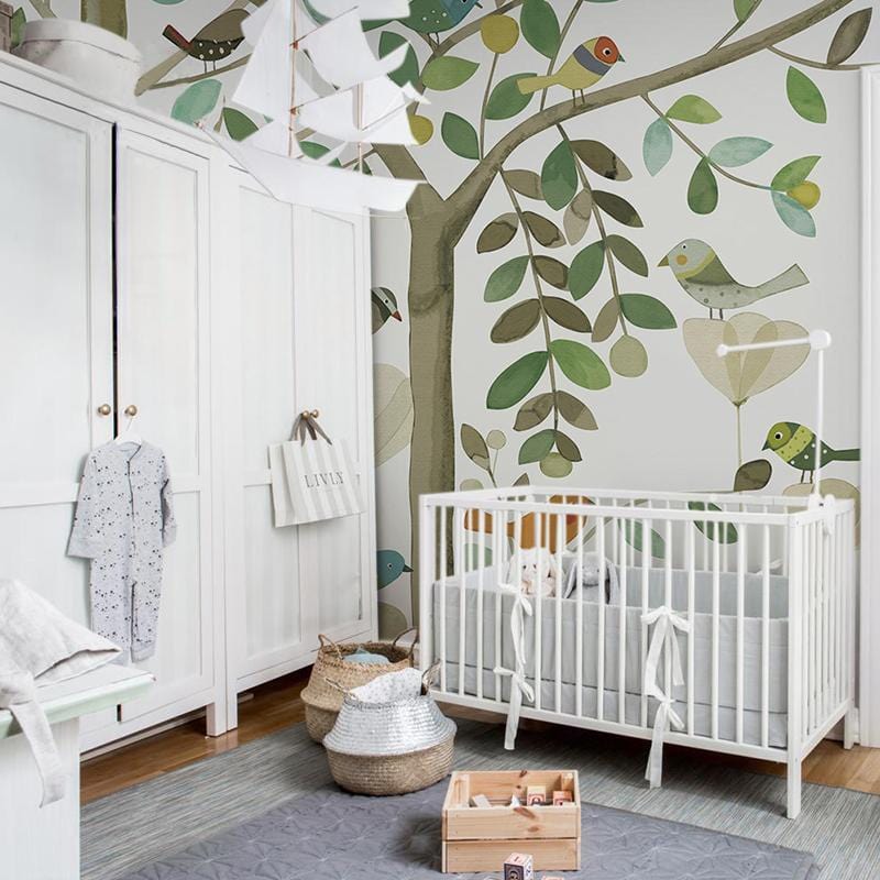 Nursery with Whimsical Woodland Birds wallpaper, earthy tones, white cot, wardrobe, wooden flooring, grey rug.