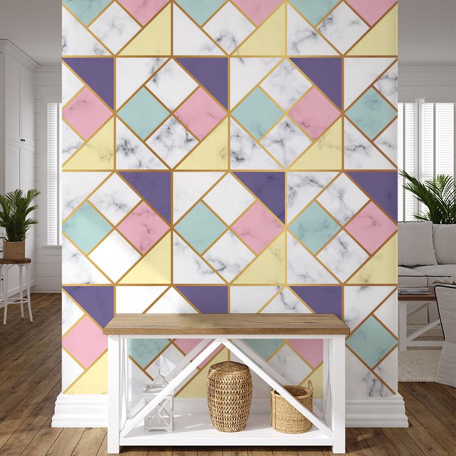 Geometric Pastel Art Deco wallpaper with marble effect, gold accents, wooden console, light grey sofa.
