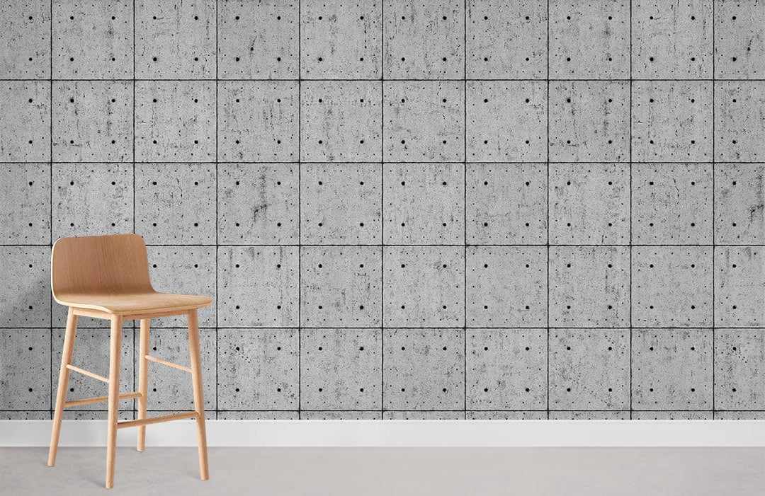 Modern industrial wallpaper with grey concrete tile effect, featuring a light wooden bar stool.