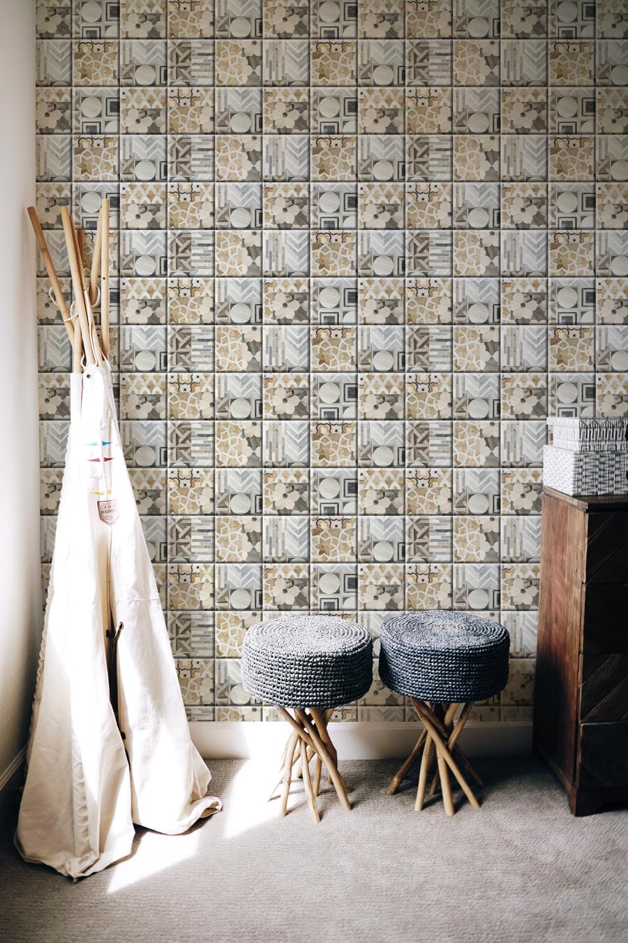 Vintage mosaic tile wallpaper in earthy tones, rustic decor, grey stools, fabric decor, wooden cabinet.