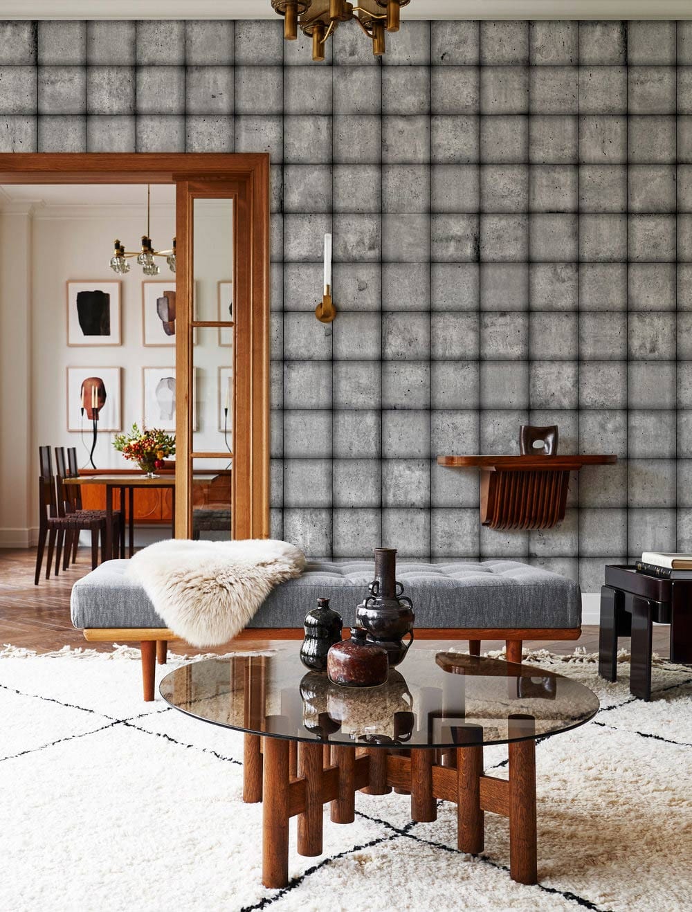 Grey industrial wallpaper with textured grid pattern in a modern living room featuring grey sofa.