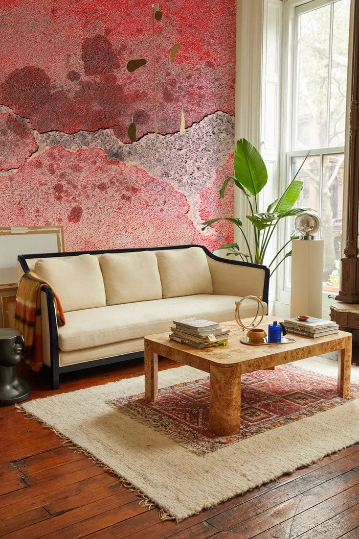 Crimson Textured Concrete Effect Wallpaper, beige sofa, rustic coffee table, wooden flooring, and window.