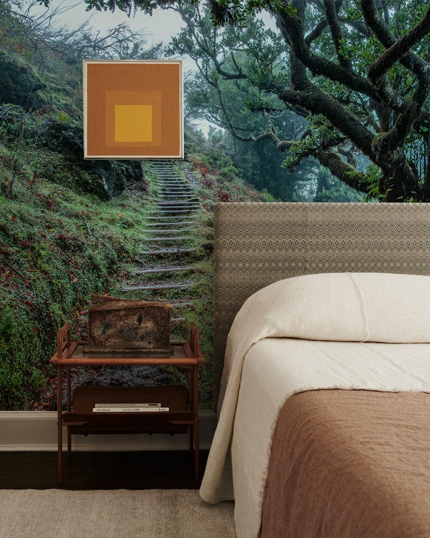 Bedroom with Enchanted Forest Trail Mural Wallpaper, cosy beige bedding, patterned headboard, modern side table.