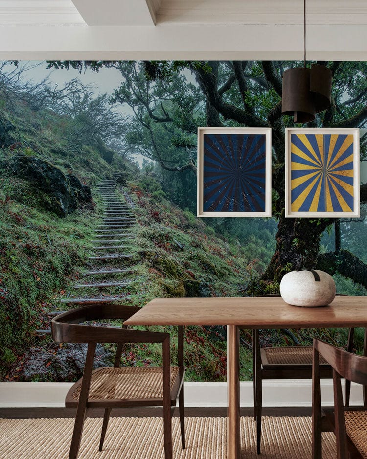 Dining room with Enchanted Forest Trail Mural Wallpaper, wooden table, woven chairs, and framed art.