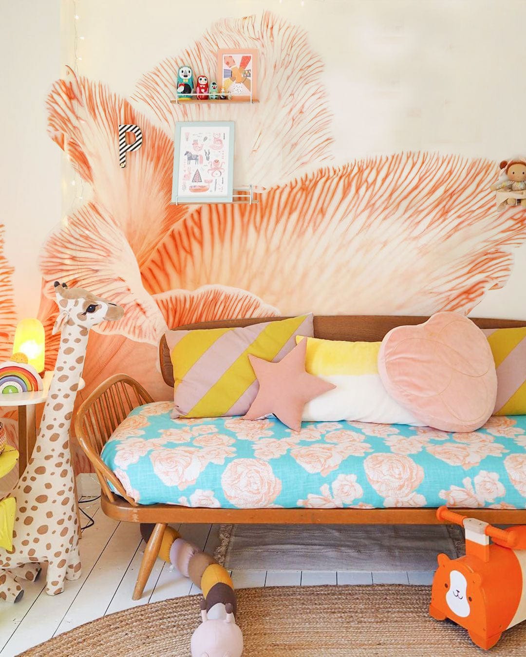 Children's room with Elegant Peach Floral Blossom Wallpaper, pastel sofa, wooden floor, and giraffe toy.