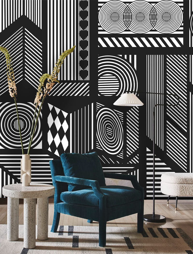 Monochrome geometric wallpaper with black armchair, grey table, modern floor lamp, and patterned rug.