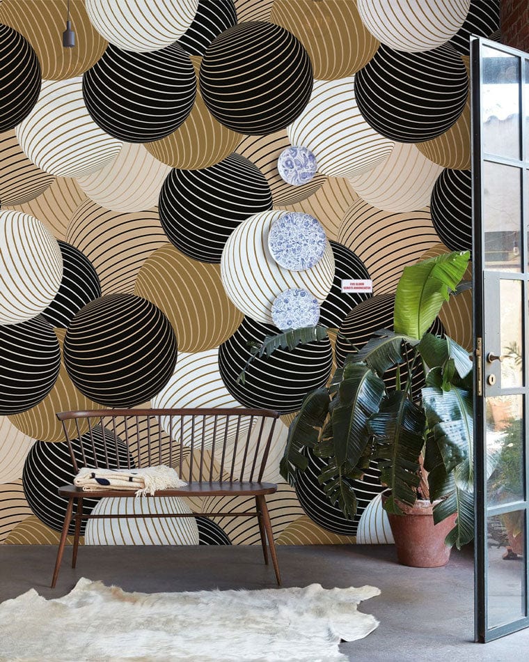 Modern Geometric Circles Wallpaper, black-gold-beige tones, wooden bench, green plant, concrete floor.