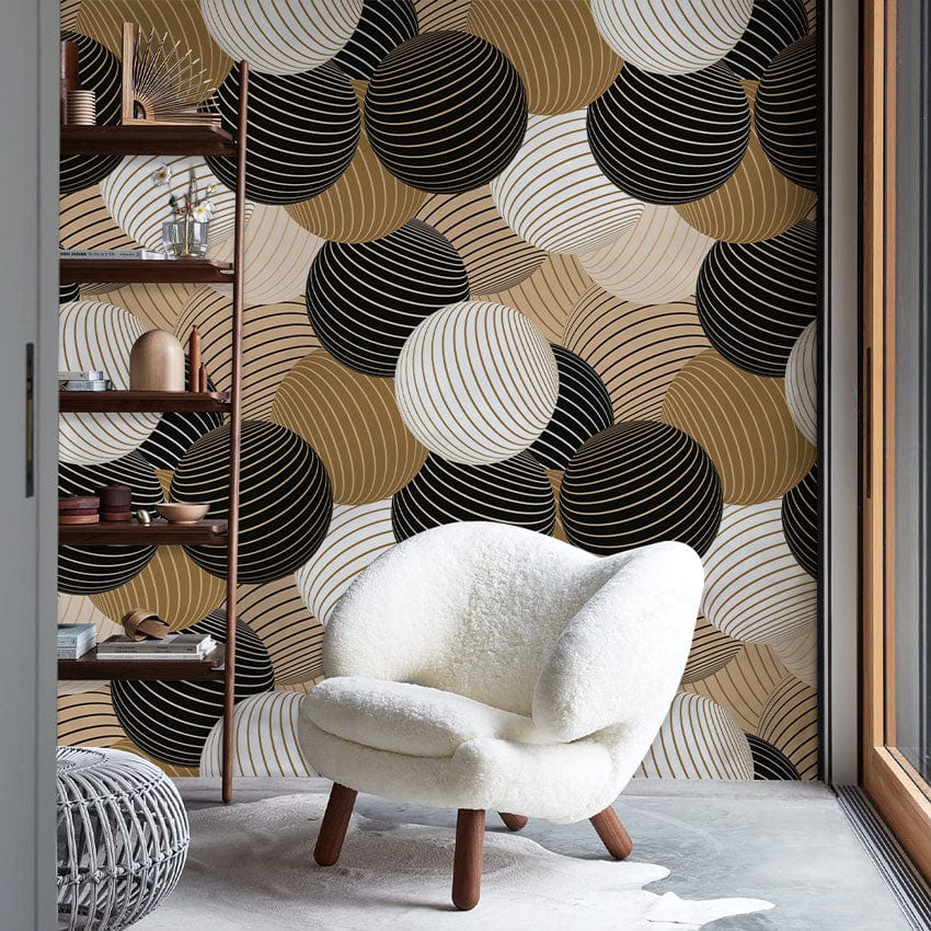 Modern Geometric Circles Wallpaper with black, gold, beige tones; cosy white chair, minimalistic room decor.