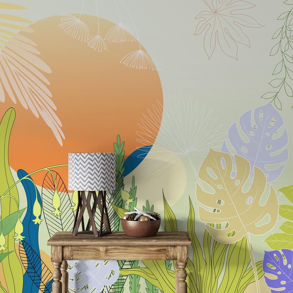 Tropical Sunset Botanical Mural Wallpaper with wooden table, patterned lampshade, and vibrant leaf design.