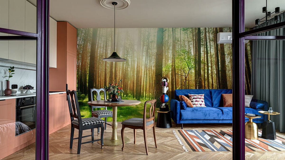 Sunlit forest mural wallpaper with blue sofa, wooden flooring, and dining set in contemporary living room.