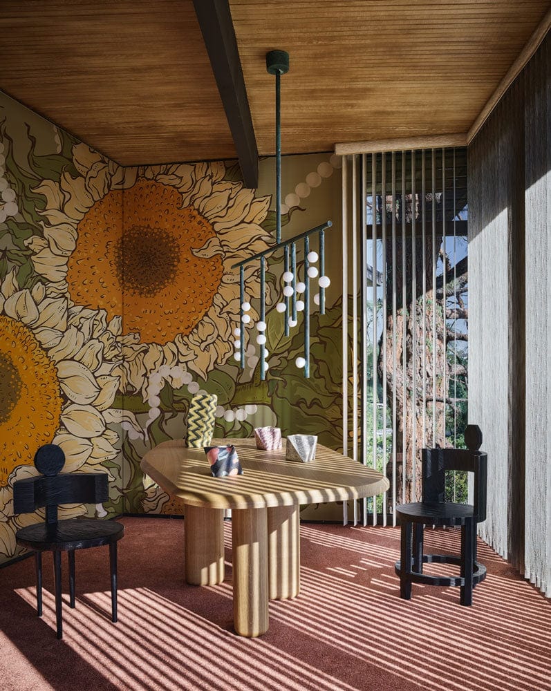 Vintage Sunflower and Pearls mural wallpaper with wooden dining table, unique chairs, pendant light in dining room.