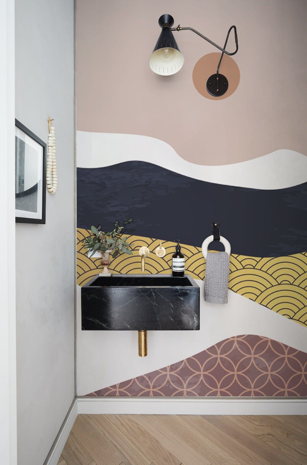 Elegant Abstract Wave Mural Wallpaper in bathroom with black marble sink, modern lamp, wooden flooring.