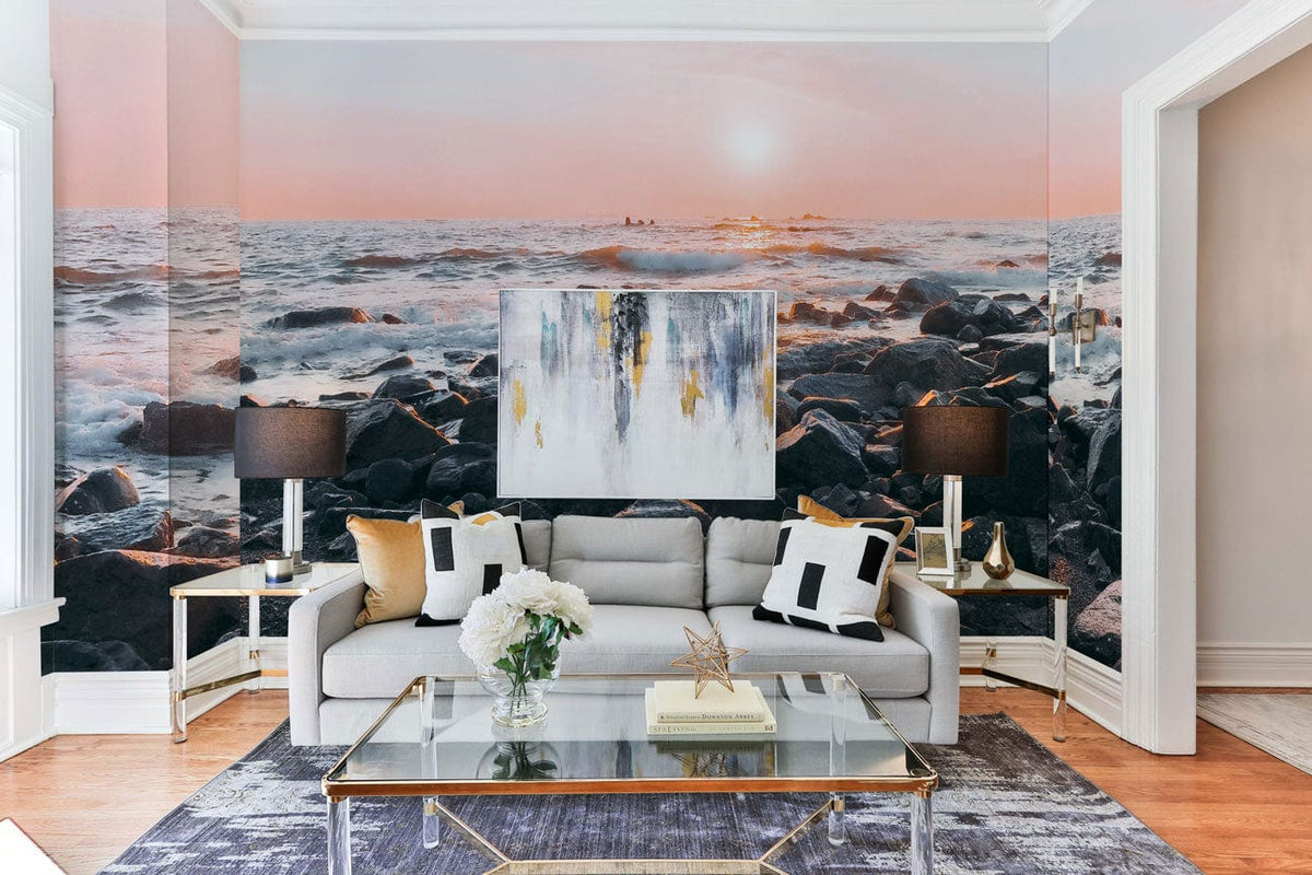 Serene Coastal Sunrise Mural Wallpaper; pastel tones, grey sofa, glass coffee table, elegant living room decor.