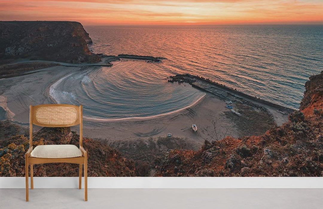 Sunset Coastal Landscape Mural Wallpaper in warm tones, featuring a wooden chair on grey flooring.
