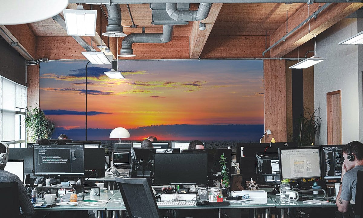 Office with Tranquil Ocean Sunset Mural Wallpaper, vibrant coastal colours, wooden beams, industrial ceiling.