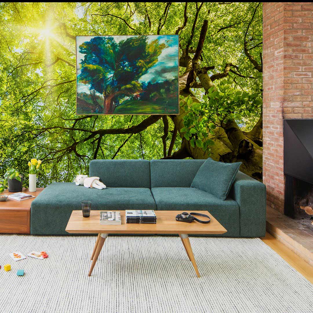 Sunlit Forest Canopy Mural Wallpaper in living room with green sofa, brick fireplace, and light wood flooring.