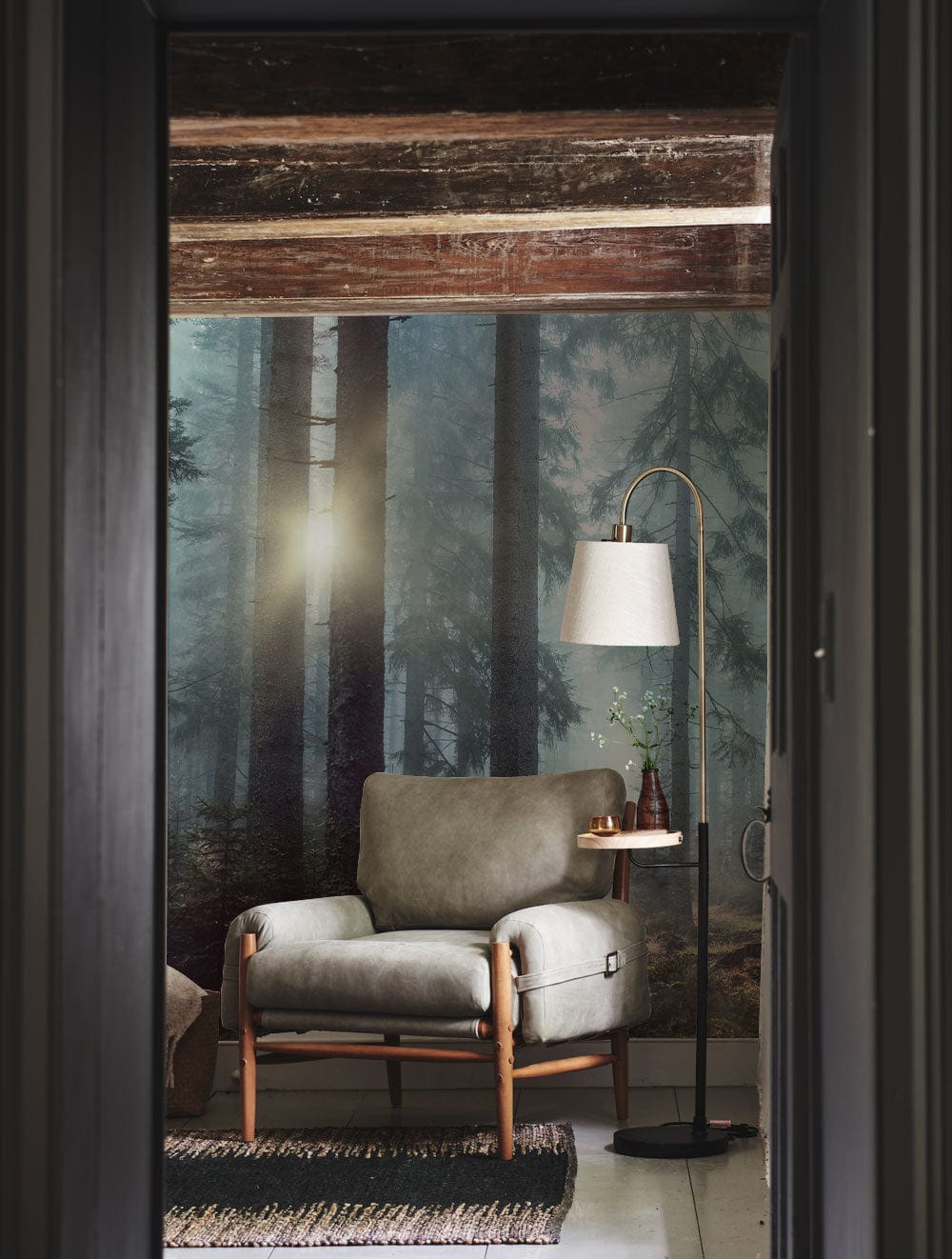 Comfortable room with Mystical Forest Sunrise Mural Wallpaper, stylish armchair, rustic beams, and elegant lamp.