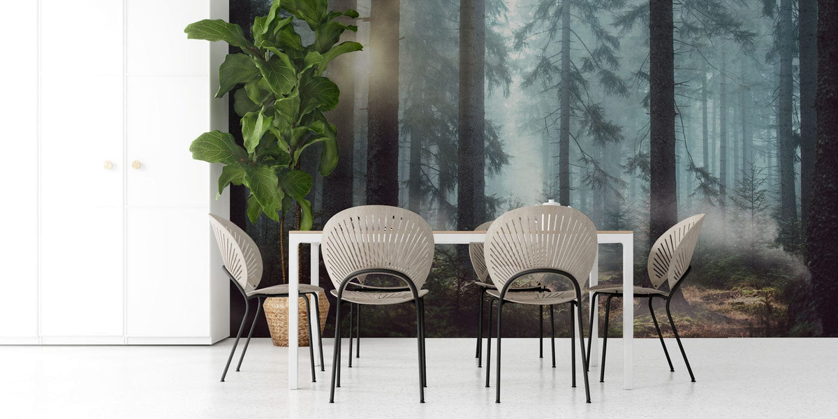 Dining area with Mystical Forest Sunrise Mural Wallpaper, modern chairs, white table, greenery, minimalist decor.