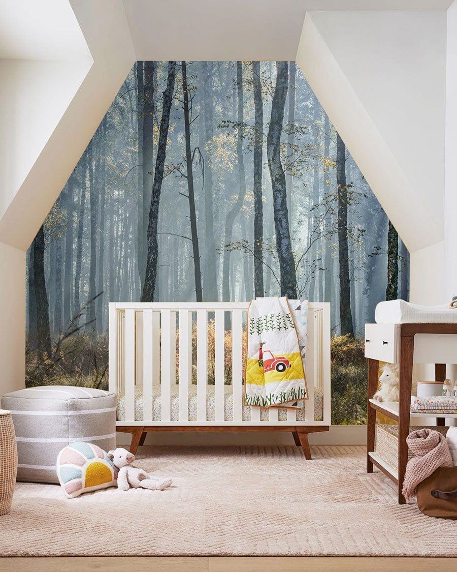 Nursery with Serene Misty Forest Mural Wallpaper, white crib, beige carpet, and changing table.