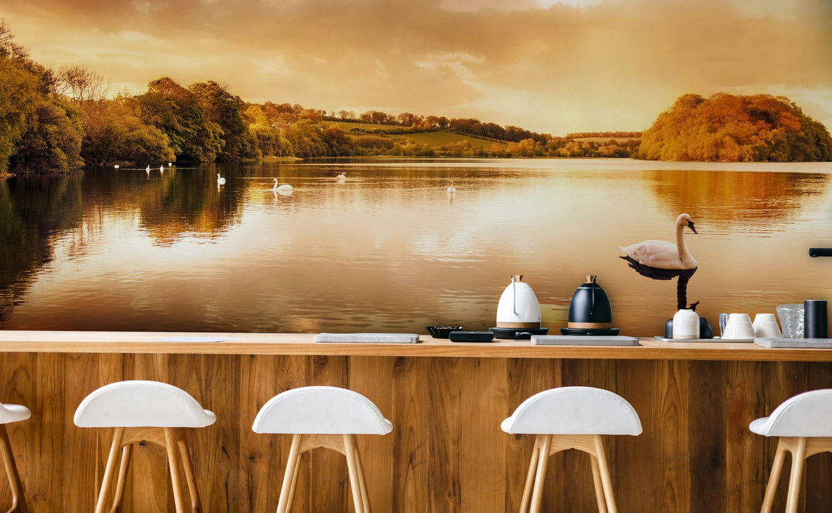 Golden Sunset Lake Scene mural in kitchen with wooden bar, white chairs, serene swan reflections.