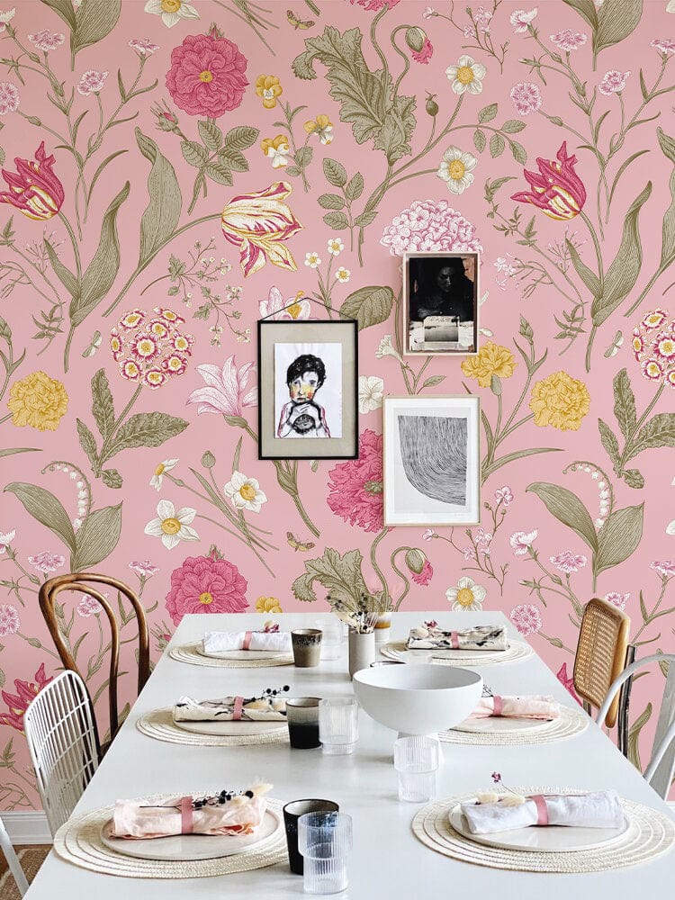 Pink floral wallpaper with botanical design, dining room decor, white table, mixed wooden chairs.