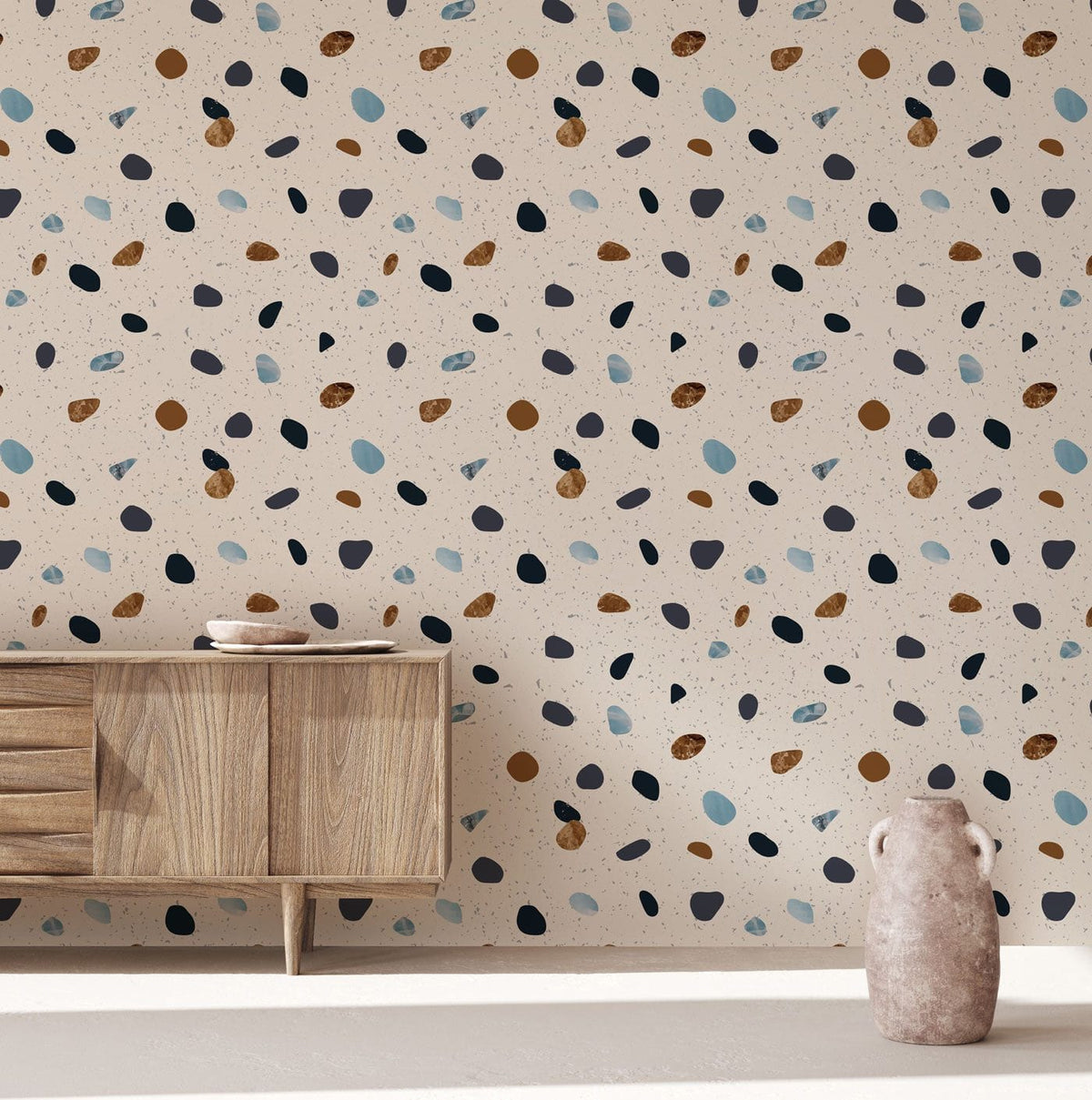 Contemporary terrazzo wallpaper in neutral and blue tones with wooden sideboard and minimalist decor vase.