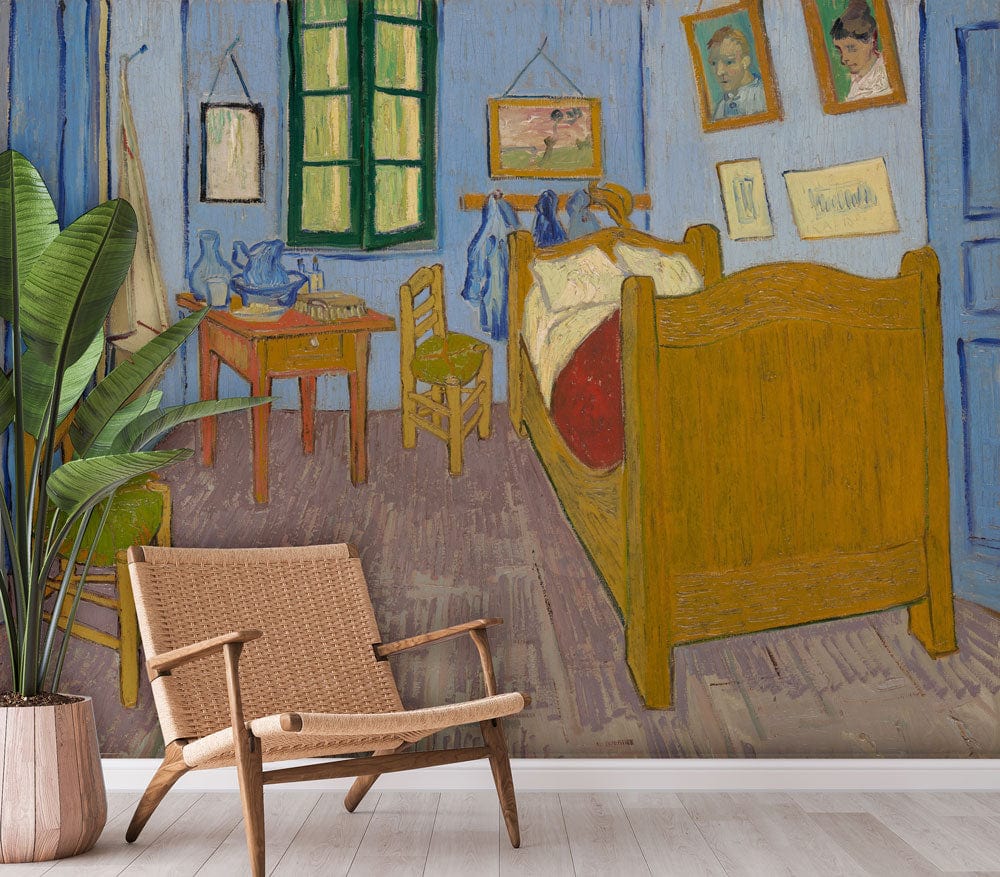 Vincent-inspired blue bedroom mural wallpaper with rustic bed, wicker chair, plant, and light wood flooring.