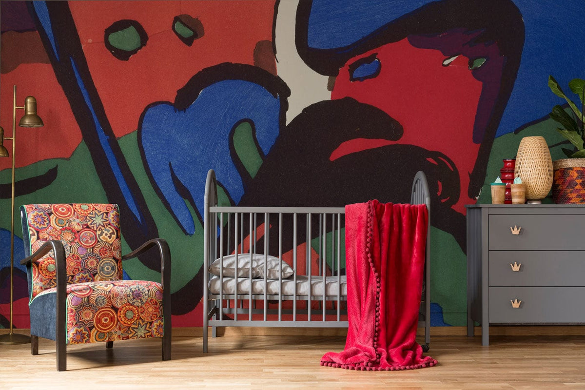 Vibrant geometric mural wallpaper, colourful armchair, grey crib, red throw, wooden flooring, modern nursery.